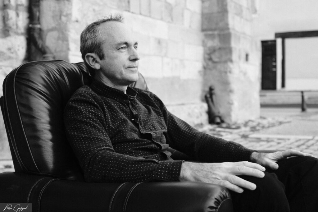 Man sitting in an armchair outdoors, black and white portrait