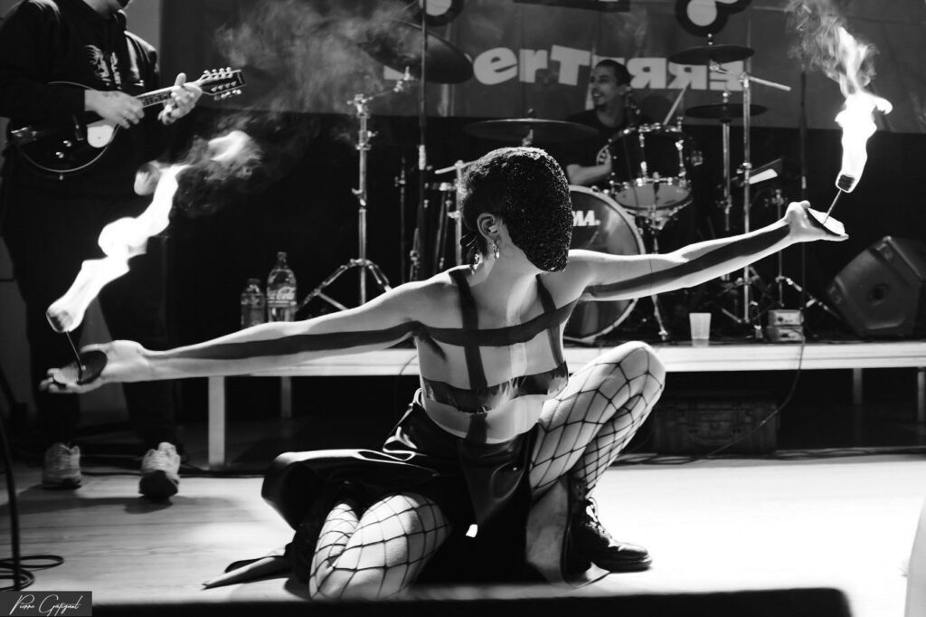 Stage performer with flames in front of musicians