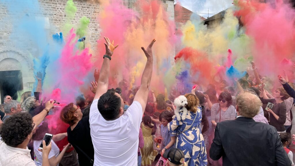 Crowd throwing coloured powders outdoors