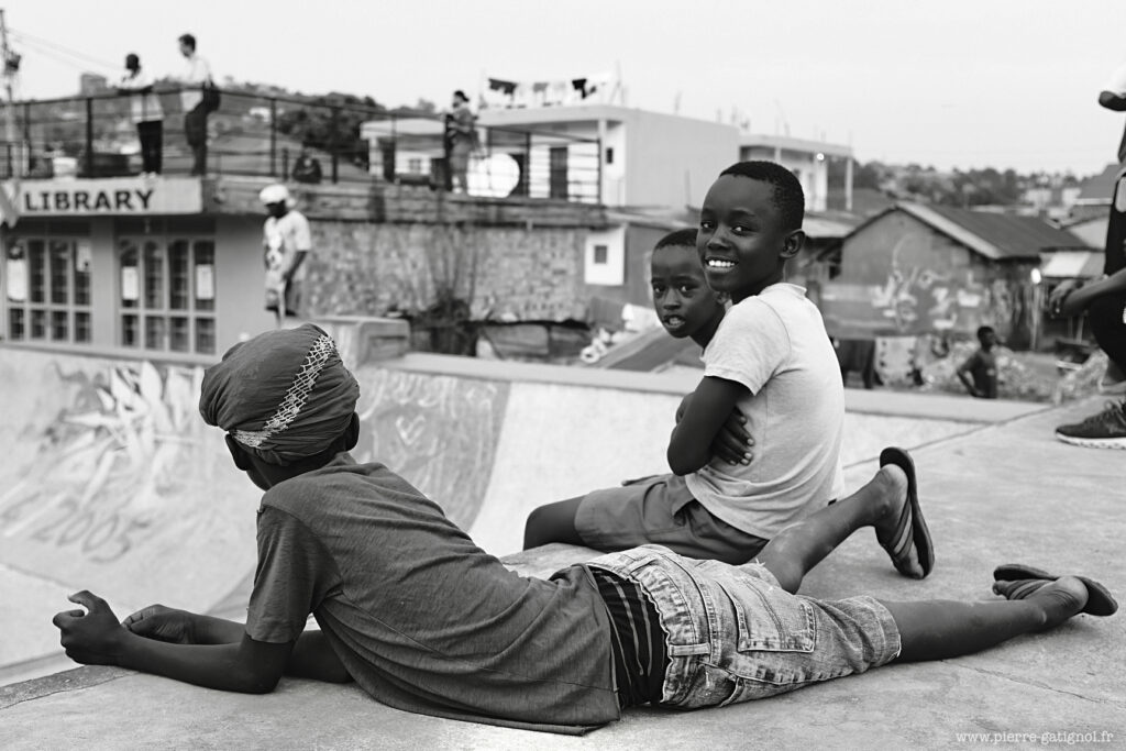 Two children sitting and lying on a slab outdoors