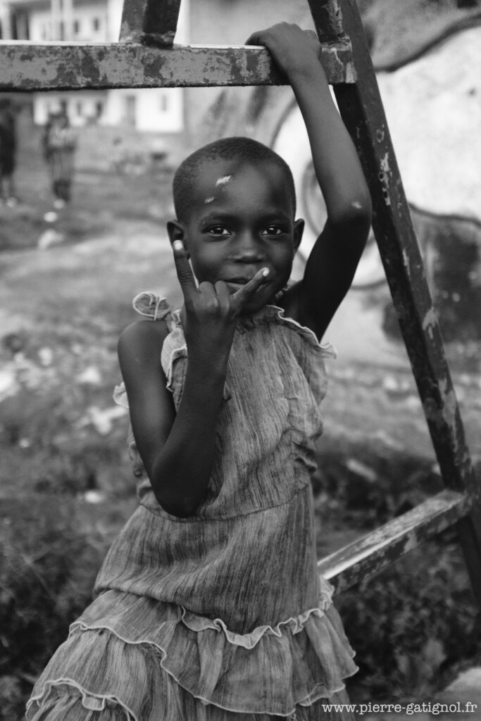 Child in a dress holding a metal structure