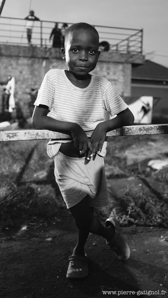 Child standing, leaning against a metal railing