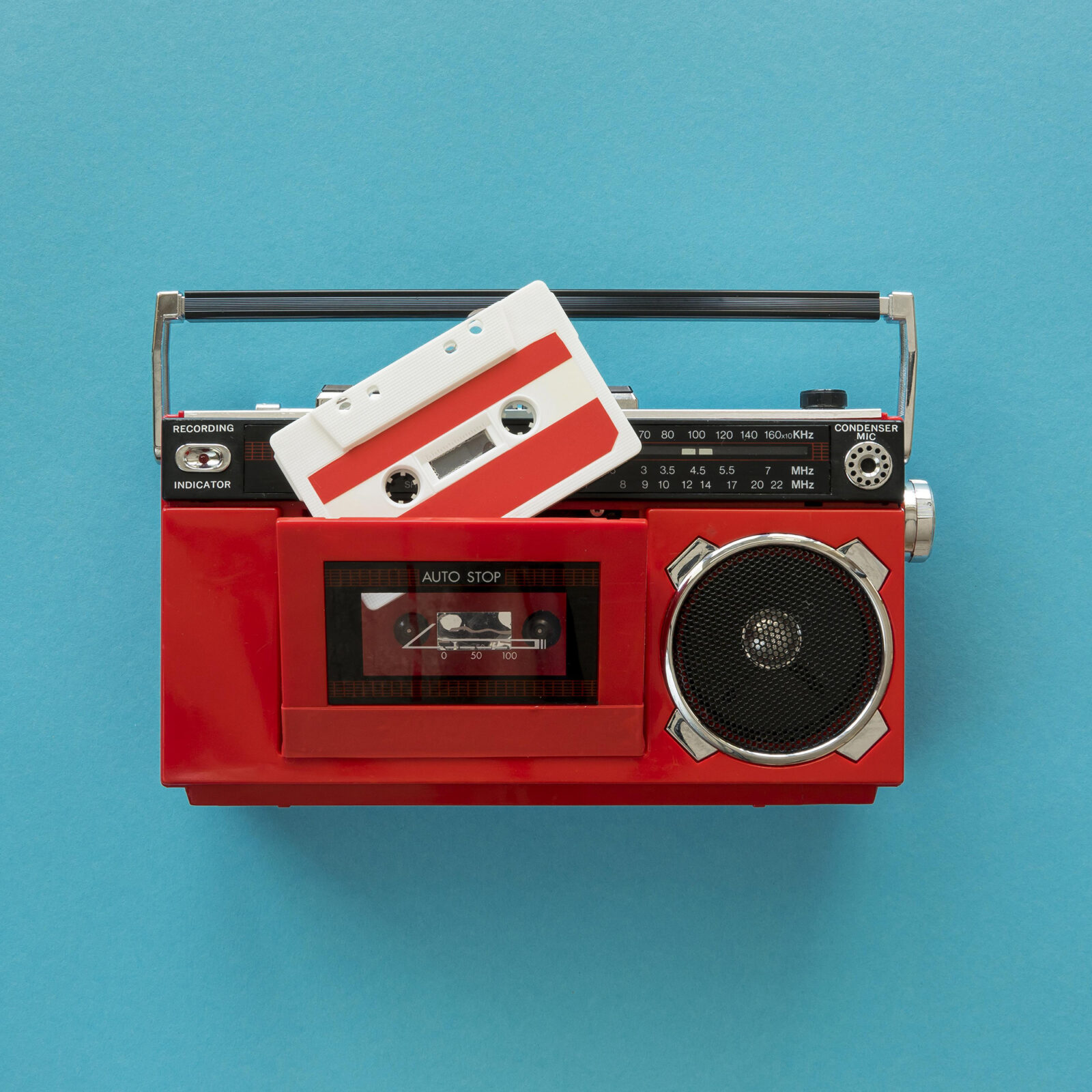 Red boombox and audio cassette for visual design Red boombox with cassette placed on top